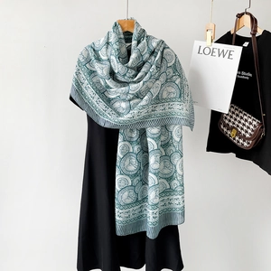 Detail of soft cotton linen shawl featuring green circular patterns and striped edges