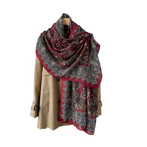 Red paisley print cotton linen long scarf draped elegantly over a khaki trench coat