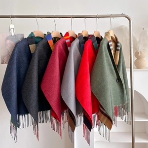 Detailaufnahme von Winter-Plaid-Ponchos mit Fransen und kontrastreichen Streifen