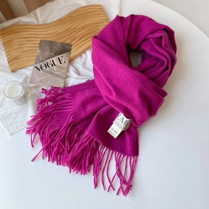 Vue détaillée d'une écharpe rose style cachemire avec des franges et étiquette blanche