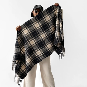 Detailed view of thick checkered scarf with long tassels in black, beige and white