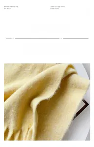 Detailed close-up of heavy yellow mohair scarf texture with long fringe tassels