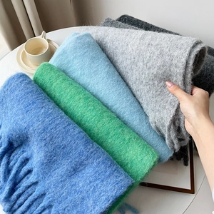 Close-up of assorted colorful mohair scarves with fluffy texture and fringed edges