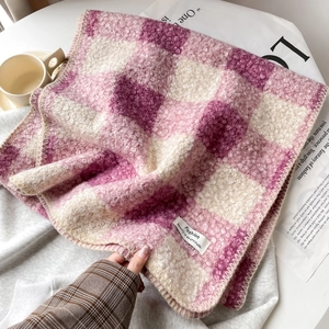 Nahaufnahme von rosa-lila kariertem Schal mit flauschiger Textur und Modewebetikett