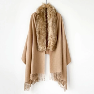 Detail of camel shawl cape featuring luxury faux fur collar and long fringe tassel hem