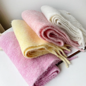 Detail of layered soft mohair knit scarves in pastel colors with long fringe trim