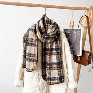 Detailstruktur des dicken karierten Schals in Braun und Creme mit warmem Fleece-Finish