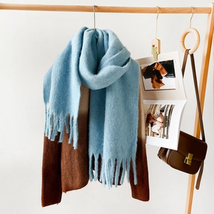 Close-up of light blue mohair scarf featuring long tassels and soft fuzzy texture