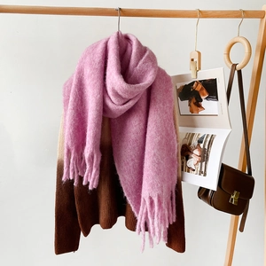 Detail of soft pink mohair wool scarf featuring thick tassels and warm fuzzy texture