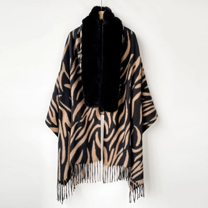 Detail of zebra pattern winter shawl featuring a black faux fox fur collar and tassels