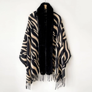 Detail of zebra pattern shawl featuring black faux fur collar and fringe tassels