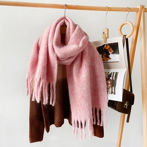 Detailed texture of pink mohair scarf with fringes hanging on wooden rack