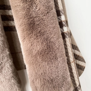 Close-up of fluffy faux fox fur trim and brown plaid cashmere-like fabric scarf