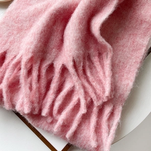 Close-up of soft pink mohair scarf showing thick tassels and fuzzy brushed texture