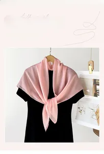 Detailansicht der Textur des leichten rosa Chiffonschals, an einem schwarzen Outfit
