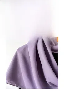 Detail von leichtem lila Perlen-Chiffon-Hijab, der an einem Holzbügel drapiert ist