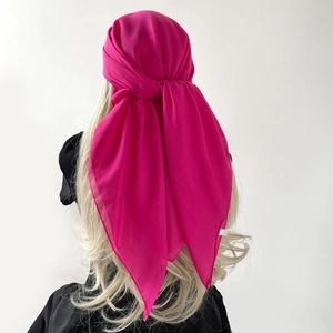 Detail eines hinten gebundenen, rosaroten Schal-Kopftuchs aus leichtem Chiffon-Stoff