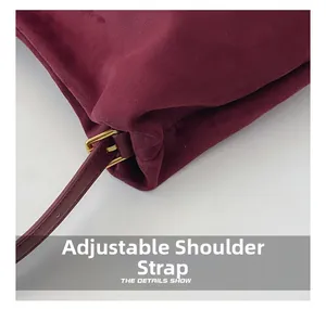 Detail of adjustable metal buckle and burgundy suede strap on Boston handbag