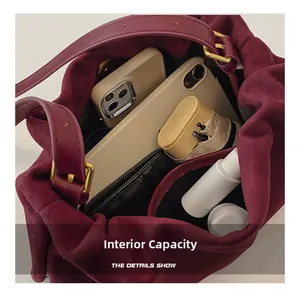 Internal capacity of the burgundy suede Boston bag showing phone and daily essentials