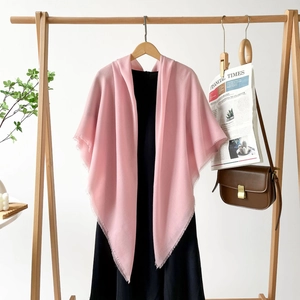 Detail of pink cotton linen scarf with fine tassel edges on wooden hanger styling