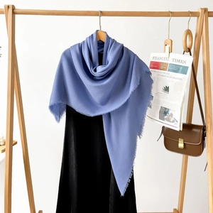 Detail of light blue scarf featuring delicate frayed edges and fine linen-like texture