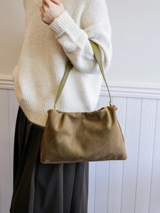 Close-up of vintage brown suede Boston bag with green leather shoulder strap detail