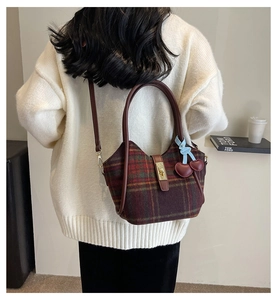 Détail du sac cabas écossais en laine avec finitions en cuir et pendentif cerise chic
