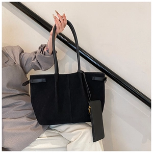 Detailopname van zwarte suède shopper met plooien en bijbehorende kleine ritsportemonnee