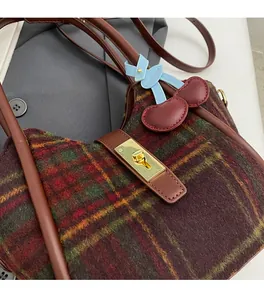 Détail du sac cabas en laine à carreaux avec fermoir doré et pendentif cerise