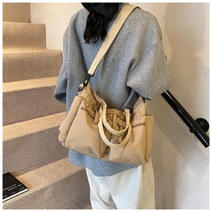 Detail of khaki canvas tote bag featuring multiple functional pockets and large capacity