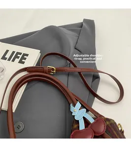 Détail de la bandoulière réglable en cuir sur un sac cabas en laine à carreaux chic