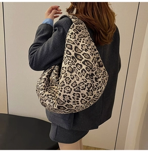 Detailed back view of a large leopard print hobo shoulder bag styled on a female model