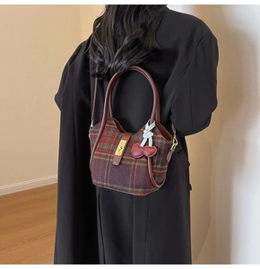 Détail du sac cabas en laine à carreaux avec breloques cerises et anses en cuir