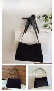 Detail view of the black suede Boston bag with gold hardware and a wide leather strap