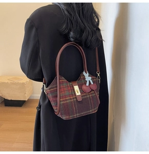 Détail du sac cabas en laine à carreaux avec pendentif cerise et boucle métallique