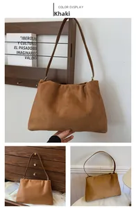 Detailed view of khaki suede Boston bag with soft texture and vintage shoulder strap