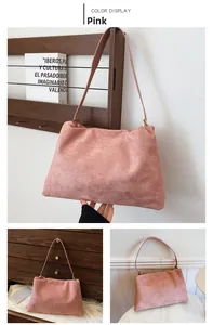 Close-up of pink suede Boston bag with delicate texture and golden metal hardware