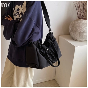 Detail of black multi-pocket tote bag with adjustable strap and woven handles