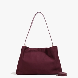 Detailed macro view of dark red suede Boston bag with adjustable shoulder strap and texture