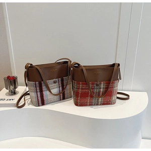 Détail du sac seau élégant en cuir marron avec un tissu en laine à carreaux texturé