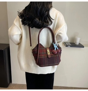 Détail du sac cabas à carreaux rouges avec fermoir doré et breloque cerise sur modèle