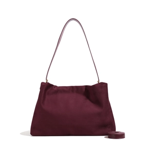 Detail view of burgundy Boston bag with suede texture and dual detachable shoulder straps