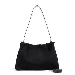 Detailed close-up of a black suede Boston bag with soft texture and golden metal hardware