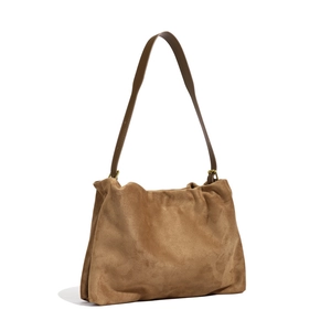 Detailed close-up of brown suede Boston bag showing texture and leather strap attachment