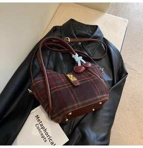 Détail du sac cabas vintage en laine à carreaux avec garniture en cuir rouge
