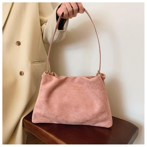 Close-up of pink suede Boston bag with delicate texture and sleek shoulder strap detail