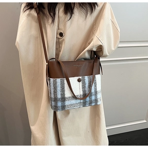 Détail d'un sac cabas en laine à carreaux montrant les coutures et la texture de qualité