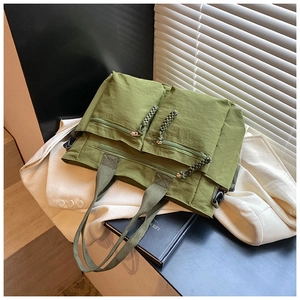 Detail view of military green tote bag showing nylon texture and rope zipper pulls
