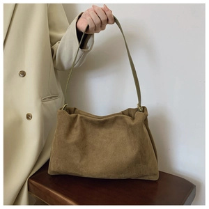 Detail of soft dark brown suede hobo bag with a minimalist leather shoulder strap