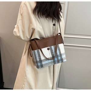 Détail du sac à bandoulière en cuir marron et tweed à carreaux bleus et gris chic